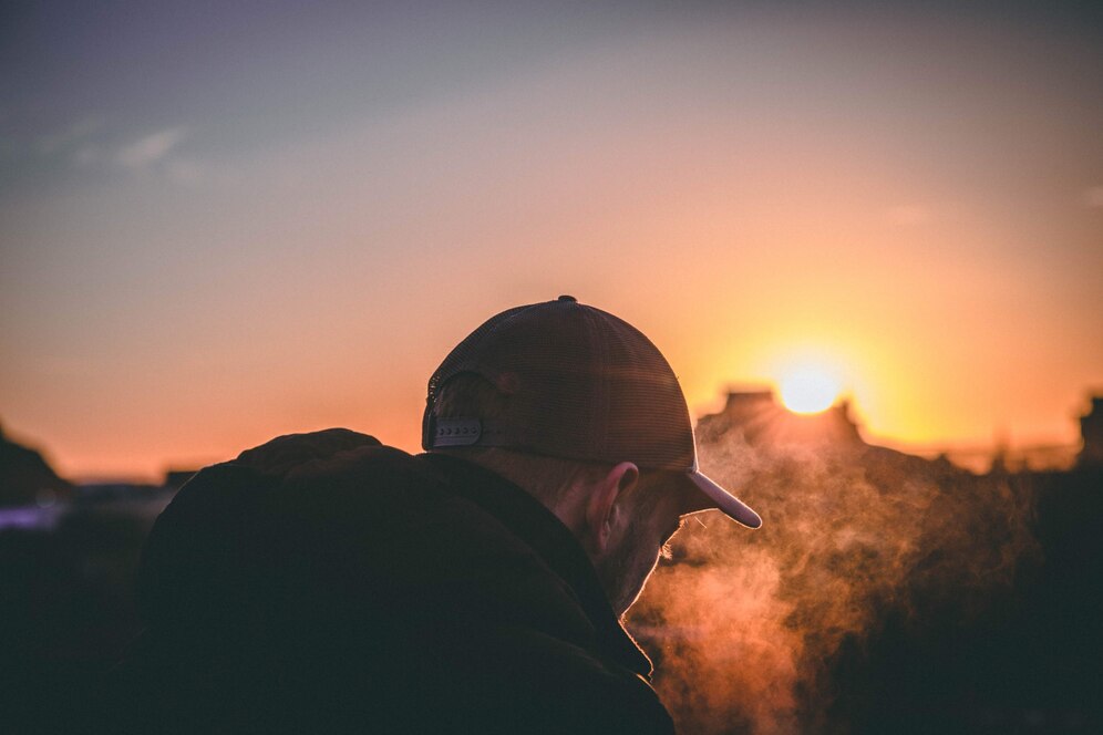 man met pet in zonsondergang