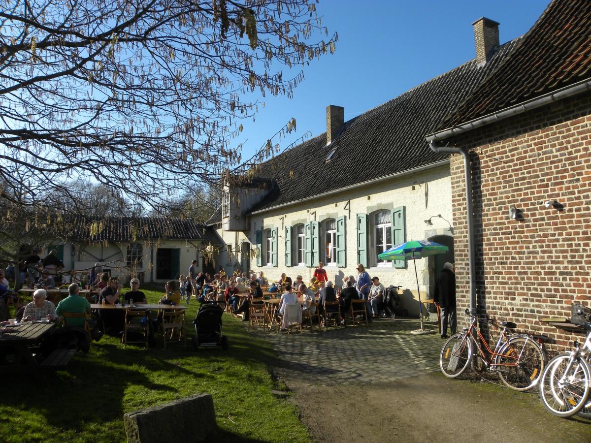 mensen drinken een glas op de binnenkoer van de Pedemolen