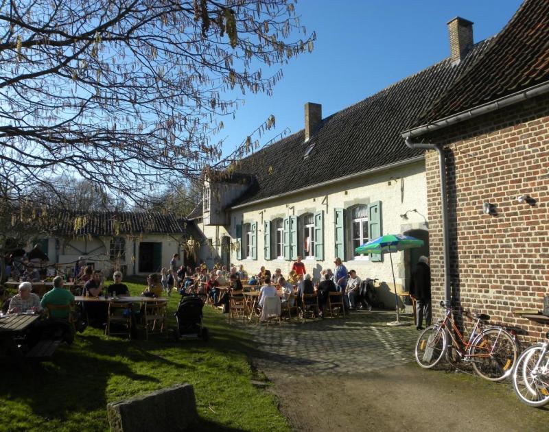 mensen drinken een glas op de binnenkoer van de Pedemolen