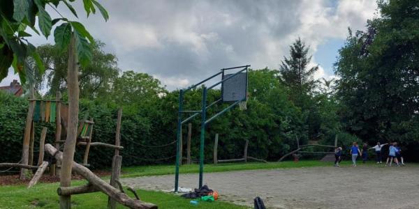 speelpleintje met baskettende jongeren