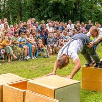 Foto van twee mannen die voor publiek op kratten klauteren